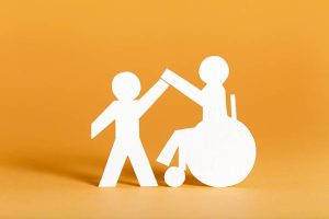 Handicapped person and helper - paper cutouts.